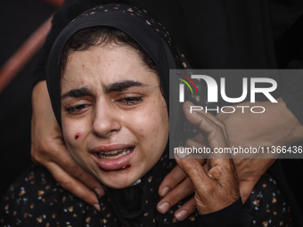 A mourner is reacting during the funeral of Palestinians killed in Israeli strikes, amid the Israel-Hamas conflict, at Al-Aqsa hospital in D...