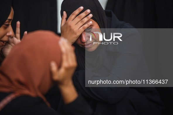 Mourners are reacting during the funeral of Palestinians killed in Israeli strikes, amid the Israel-Hamas conflict, at Al-Aqsa hospital in D...