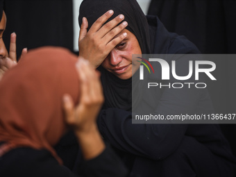 Mourners are reacting during the funeral of Palestinians killed in Israeli strikes, amid the Israel-Hamas conflict, at Al-Aqsa hospital in D...