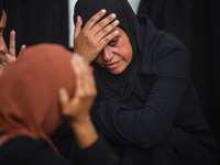 Mourners are reacting during the funeral of Palestinians killed in Israeli strikes, amid the Israel-Hamas conflict, at Al-Aqsa hospital in D...