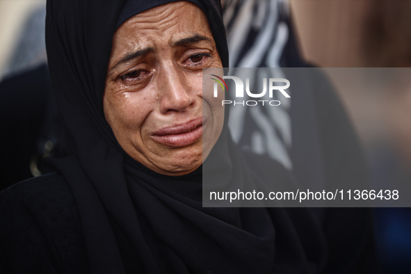 A mourner is reacting during the funeral of Palestinians killed in Israeli strikes, amid the Israel-Hamas conflict, at Al-Aqsa hospital in D...