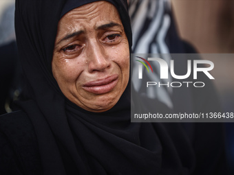 A mourner is reacting during the funeral of Palestinians killed in Israeli strikes, amid the Israel-Hamas conflict, at Al-Aqsa hospital in D...