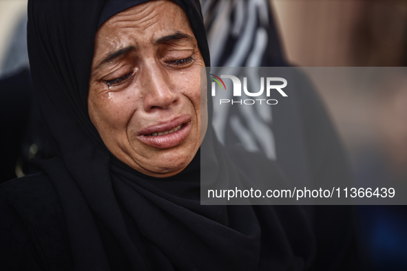 A mourner is reacting during the funeral of Palestinians killed in Israeli strikes, amid the Israel-Hamas conflict, at Al-Aqsa hospital in D...