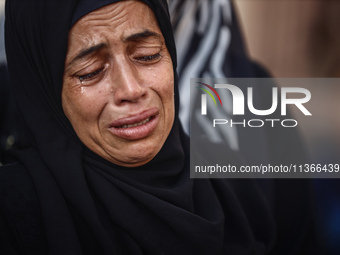 A mourner is reacting during the funeral of Palestinians killed in Israeli strikes, amid the Israel-Hamas conflict, at Al-Aqsa hospital in D...