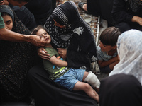 Mourners are reacting during the funeral of Palestinians killed in Israeli strikes, amid the Israel-Hamas conflict, at Al-Aqsa hospital in D...