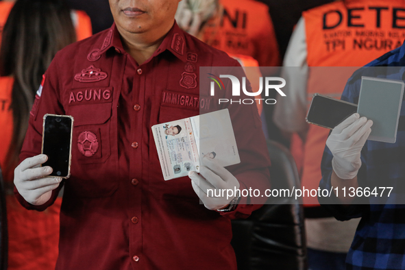 Indonesian immigration authorities are showing handphones and a Taiwan national passport during a press conference at the Immigration Detent...