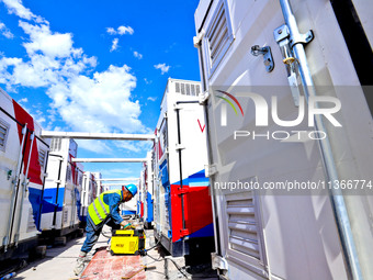 Builders are installing auxiliary equipment of the vanadium flow battery energy storage system at the site of Source Energy Technology's 250...