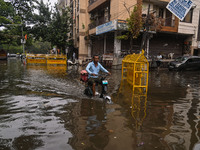 A food delivery person is riding his electric bike through a flooded street after heavy rains in New Delhi, India, on June 28, 2024. (