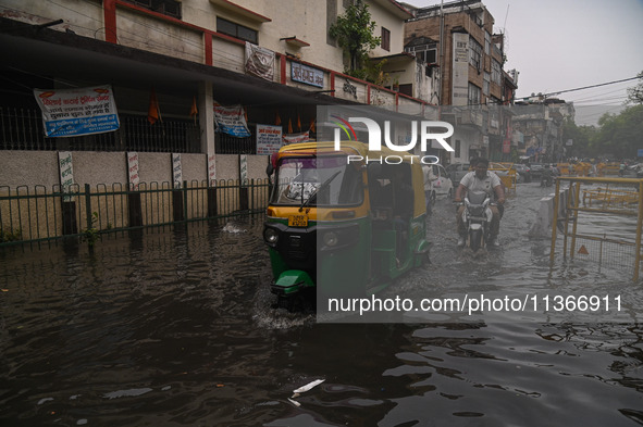 An autorickshaw is wading through a flooded street after heavy rains in New Delhi, India, on June 28, 2024. 