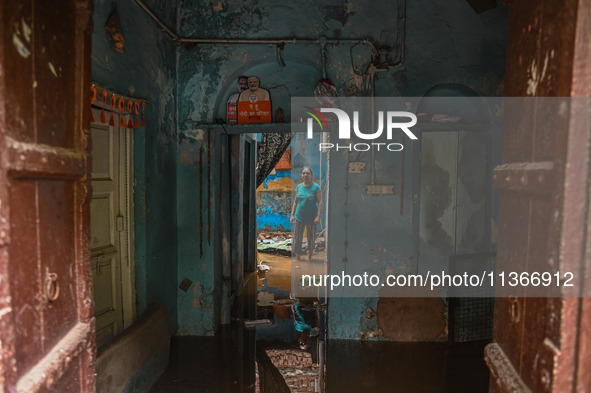 Unnati Prakash, 42, is standing inside her room as she is showing her house that was flooded with water after heavy rains in New Delhi, Indi...