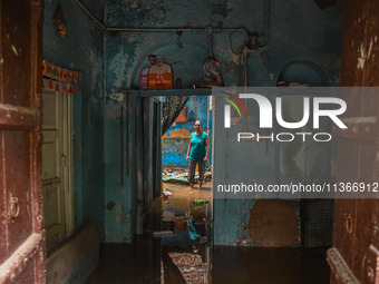 Unnati Prakash, 42, is standing inside her room as she is showing her house that was flooded with water after heavy rains in New Delhi, Indi...