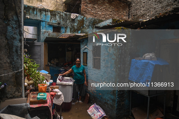 Unnati Prakash, 42, is standing inside her room as she is showing her house that was flooded with water after heavy rains in New Delhi, Indi...