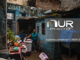 Unnati Prakash, 42, is standing inside her room as she is showing her house that was flooded with water after heavy rains in New Delhi, Indi...