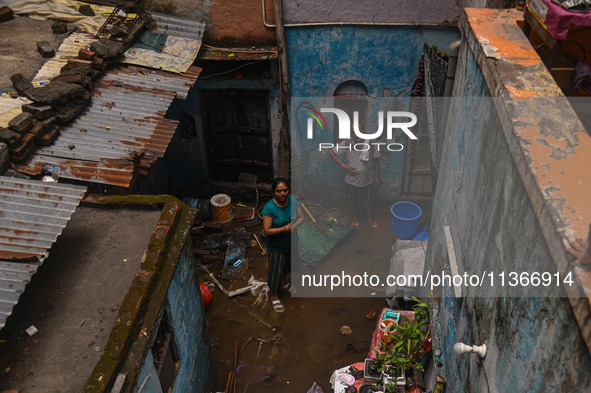 Unnati Prakash, 42, is standing inside her room as she is showing her house that was flooded with water after heavy rains in New Delhi, Indi...