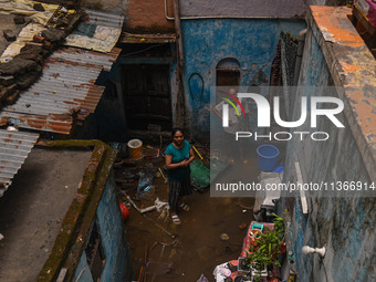 Unnati Prakash, 42, is standing inside her room as she is showing her house that was flooded with water after heavy rains in New Delhi, Indi...