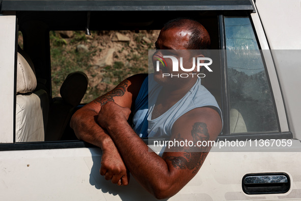 A pilgrim is boarding a vehicle as they are moving towards a Basecamp for Amarnath Yatra in Pahalgam, Jammu and Kashmir, India, on June 28,...