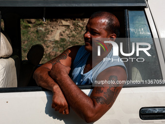 A pilgrim is boarding a vehicle as they are moving towards a Basecamp for Amarnath Yatra in Pahalgam, Jammu and Kashmir, India, on June 28,...