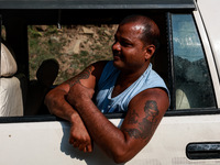 A pilgrim is boarding a vehicle as they are moving towards a Basecamp for Amarnath Yatra in Pahalgam, Jammu and Kashmir, India, on June 28,...