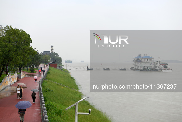 Citizens are walking along the Yangtze River in Jiujiang city, Jiangxi province, China, on June 28, 2024. The water level at Jiujiang Statio...