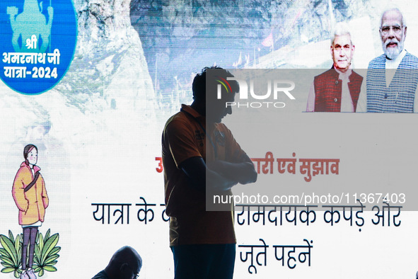 A devotee is standing inside a tent with PM Modi and LG Manoj Sinha's picture flashing on a screen inside Nunwan basecamp in Pahalgam, Jammu...