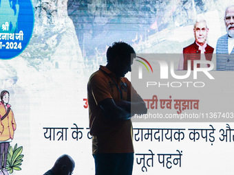 A devotee is standing inside a tent with PM Modi and LG Manoj Sinha's picture flashing on a screen inside Nunwan basecamp in Pahalgam, Jammu...