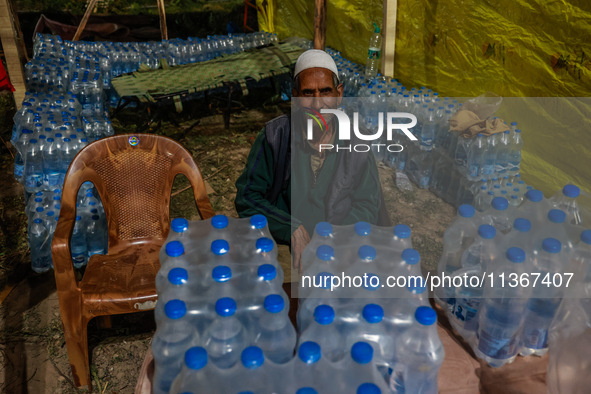 Ghulam Mohammad, 78, a Kashmiri Muslim vendor, is selling water bottles to Amarnath Pilgrims inside Nunwan Basecamp in Pahalgam, Jammu and K...