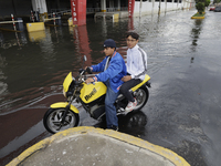 Young people are trying to pass on motorbikes outside a flooded shopping mall in Ecatepec, State of Mexico, due to the rains during the last...