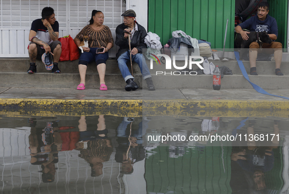 Families are standing outside their flooded homes in Ecatepec, State of Mexico, as a result of the rains during the last few days. 