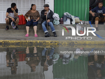 Families are standing outside their flooded homes in Ecatepec, State of Mexico, as a result of the rains during the last few days. (