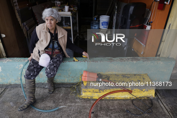 A woman is standing outside her flooded business in Ecatepec, State of Mexico, as a result of the rains during the last few days. 