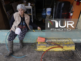 A woman is standing outside her flooded business in Ecatepec, State of Mexico, as a result of the rains during the last few days. (