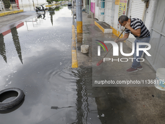 Families are standing outside their flooded homes in Ecatepec, State of Mexico, as a result of the rains during the last few days. (