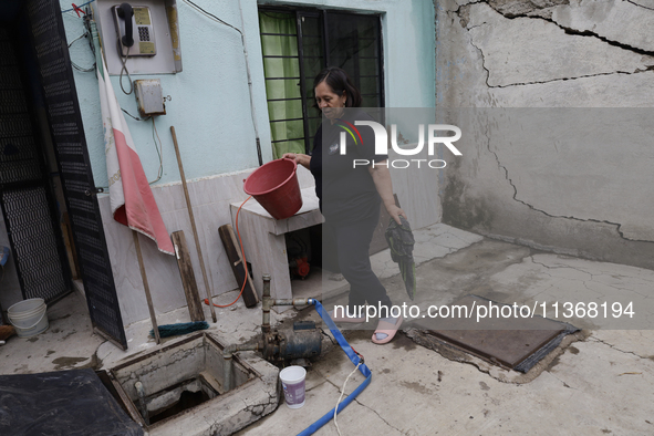 A woman is standing outside her home affected by flooding in Ecatepec, State of Mexico, due to the rains during the last few days. 