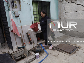 A woman is standing outside her home affected by flooding in Ecatepec, State of Mexico, due to the rains during the last few days. (