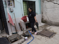 A woman is standing outside her home affected by flooding in Ecatepec, State of Mexico, due to the rains during the last few days. (