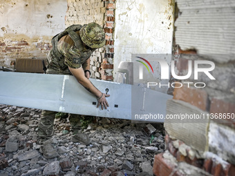 An aerial reconnaissance man of the 148th separate artillery brigade of the Ukrainian Air Assault Forces is assembling a drone before launch...