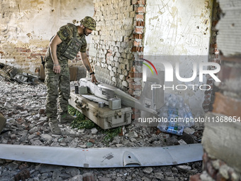 An aerial reconnaissance man of the 148th separate artillery brigade of the Ukrainian Air Assault Forces is assembling a drone before launch...