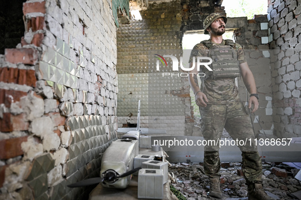 An aerial reconnaissance man of the 148th separate artillery brigade of the Ukrainian Air Assault Forces is being pictured by a disassembled...