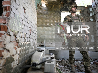 An aerial reconnaissance man of the 148th separate artillery brigade of the Ukrainian Air Assault Forces is being pictured by a disassembled...