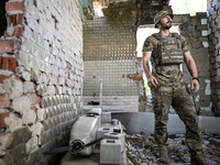 An aerial reconnaissance man of the 148th separate artillery brigade of the Ukrainian Air Assault Forces is being pictured by a disassembled...