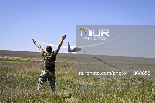 An aerial reconnaissance man of the 148th separate artillery brigade of the Ukrainian Air Assault Forces is launching a drone in the air in...