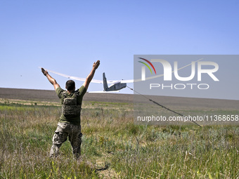 An aerial reconnaissance man of the 148th separate artillery brigade of the Ukrainian Air Assault Forces is launching a drone in the air in...