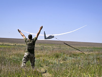 An aerial reconnaissance man of the 148th separate artillery brigade of the Ukrainian Air Assault Forces is launching a drone in the air in...