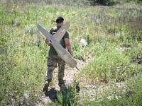 An aerial reconnaissance man of the 148th separate artillery brigade of the Ukrainian Air Assault Forces is carrying a disassembled drone to...