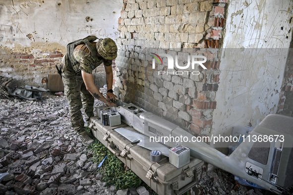 An aerial reconnaissance man of the 148th separate artillery brigade of the Ukrainian Air Assault Forces is assembling a drone before launch...