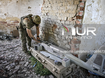 An aerial reconnaissance man of the 148th separate artillery brigade of the Ukrainian Air Assault Forces is assembling a drone before launch...