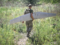 An aerial reconnaissance man of the 148th separate artillery brigade of the Ukrainian Air Assault Forces is carrying a disassembled drone to...