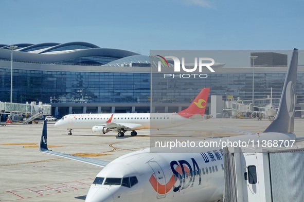 A passenger plane is sliding into the parking stand at the T2 terminal of Yantai Penglai International Airport in Yantai, China, on June 28,...