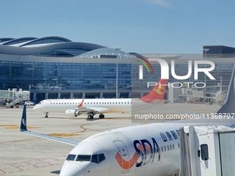 A passenger plane is sliding into the parking stand at the T2 terminal of Yantai Penglai International Airport in Yantai, China, on June 28,...