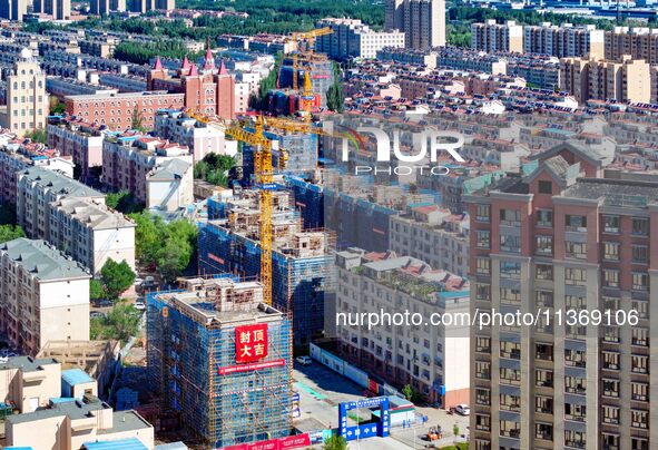 Builders are working at the construction site of a house renovation project in Baotou, Inner Mongolia, China, on June 29, 2024. 